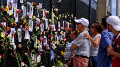 Người dân tụ tập tại một địa điểm tưởng niệm trước một tòa nhà chung cư bị sập một phần trong khi lực lượng cứu hộ tiếp tục tìm kiếm những người sống sót, ở Surfside gần Miami Beach, bang Florida, U.S., ngày 26 tháng 6, 2021. 