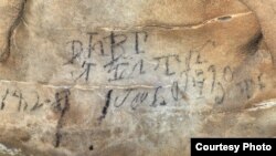 An inscription on the Manitou Cave wall, written in the Cherokee syllabary, identifies writers as stickball team leader and is dated April 30, 1828. Photo courtesy Beau Carroll, archaeologist, Eastern Band of Cherokee.