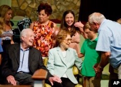 Former President Jimmy Carter (l) sits with his wife Rosalynn as they pose for photos with church members on Aug. 23, 2015, in Plains, Ga.