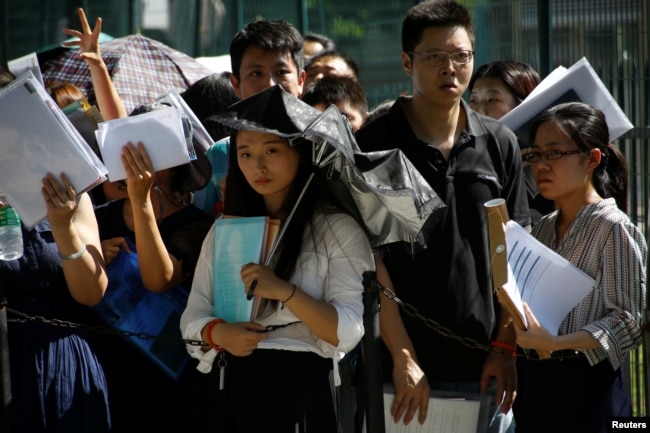 人們在在中國北京的美國大使館外排隊等候（2018年7月26日）。