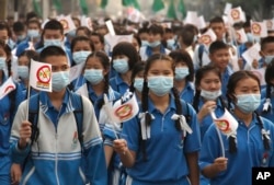 FILE - Thai schoolchildren wear masks and march on the street in a campaign to fight against the haze and smog in Chiang Mai province, northern Thailand, March 19, 2012.