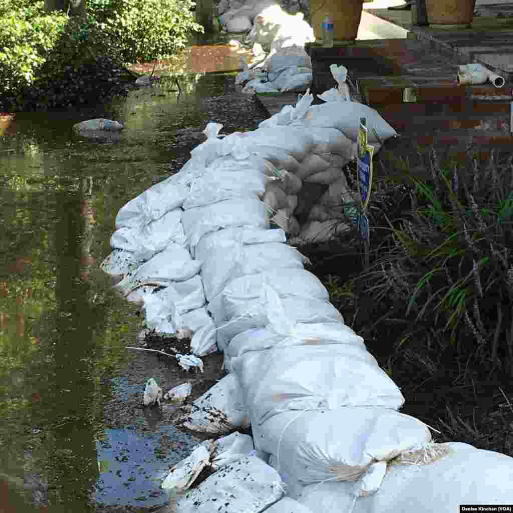 Karung-karung pasir digunakan untuk menghalangi banjir masuk ke rumah di St. Amant, Louisiana (18/8).