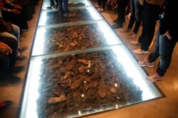 Pengunjung berdiri di sebelah pameran yang terdiri dari sepatu milik korban Holocaust selama kunjungan ke Museum Sejarah Holocaust Yad Vashem di Yerusalem 4 Mei 2016. (Foto: REUTERS/Ronen Zvulun)