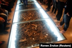 Pengunjung berdiri di sebelah pameran yang terdiri dari sepatu milik korban Holocaust selama kunjungan ke Museum Sejarah Holocaust Yad Vashem di Yerusalem 4 Mei 2016. (Foto: REUTERS/Ronen Zvulun)