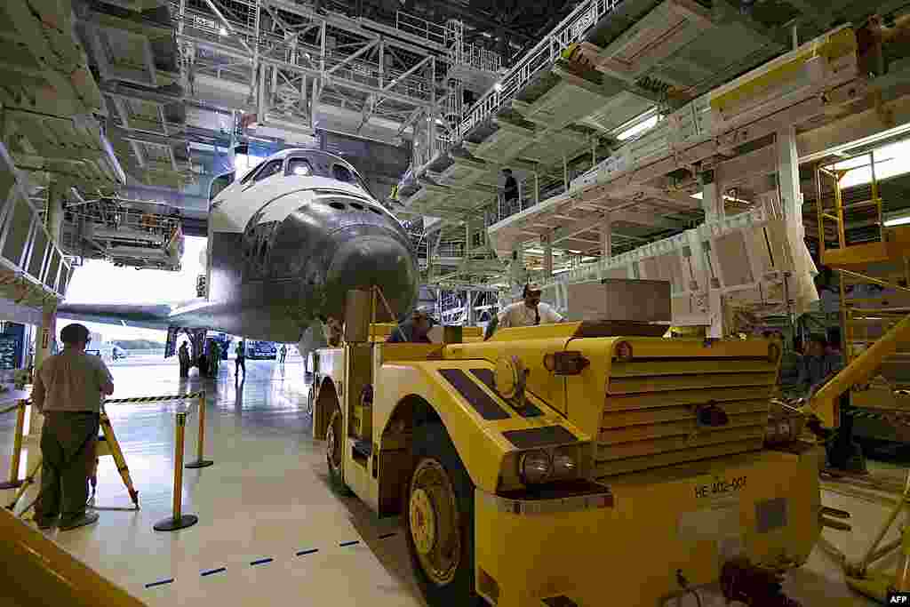 A "towback" vehicle positions space shuttle Discovery between the extensible work platforms of Orbiter Processing Facility-2 at NASA's Kennedy Space Center in Florida, March 9, 2011. (NASA)