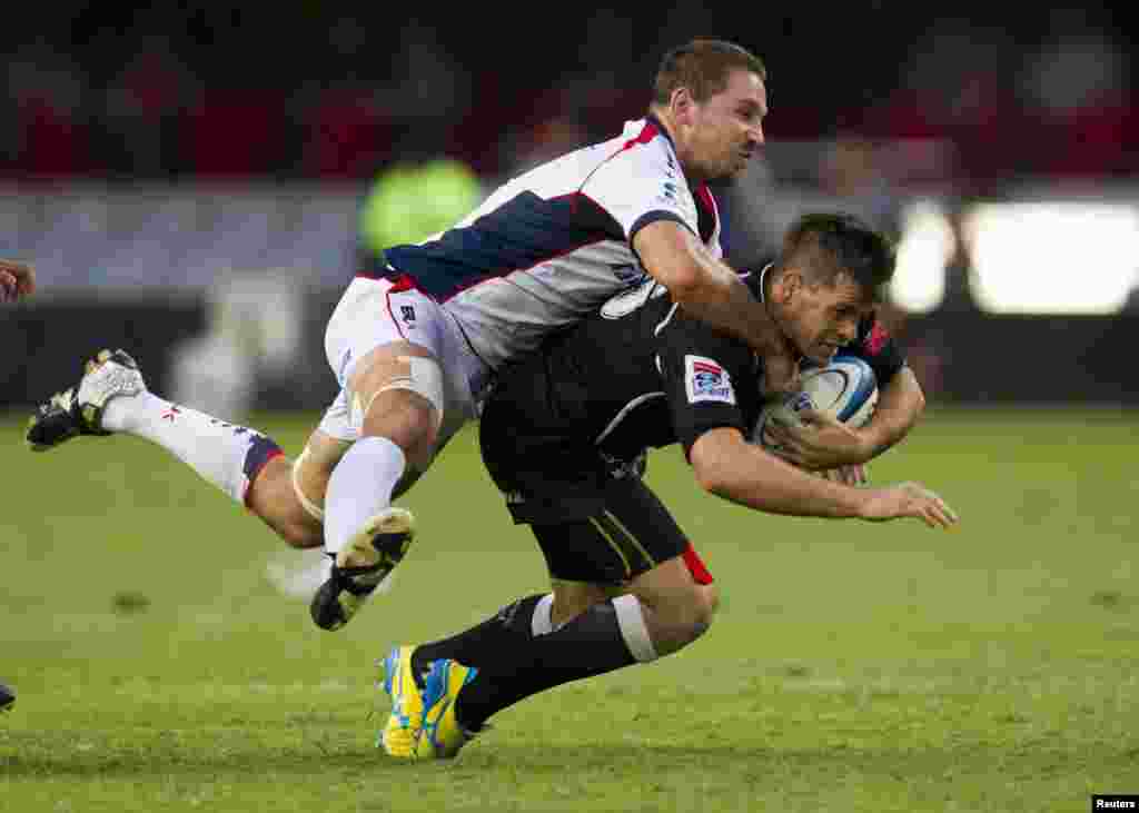 Ged Robinson (kiri) dari tim Australia Melbourne Rebels menggasak Louis Ludik dari tim Afrika Selatan Sharks dalam pertandingan rugbi Super 15 di Durban, Afrika Selatan.