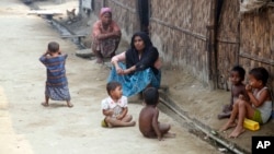 Rohingya Muslims sit on the ground at Da Paing camp for Muslim refugees in north of Sittwe, Rakhine State, western Myanmar, April 2, 2014. 