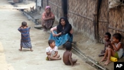 FILE - Myanmar Muslims, who identify themselves as long-persecuted “Rohingya” Muslims, sit on the ground at Da Paing camp for Muslim refugees in north of Sittwe, Rakhine State, western Myanmar.