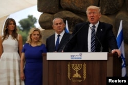 U.S. President Donald Trump, flanked by Israel's Prime Minister Benjamin Netanyahu (3rd L) and their wives Melania Trump (L) and Sara Netanyahu (2nd L), delivers remarks after a wreath-laying at the Yad Vashem holocaust memorial in Jerusalem, May 23, 2017