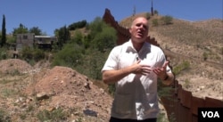 Reverend Randy Mayer by the border wall in Nogales, Mexico. (G. Flakus/VOA)