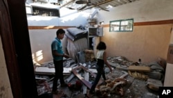 برادر و خواهر فلسطینی در حال بررسی خانه خود در غزه که پس از برخورد موشک، به ویرانه‌ای تبدیل شده است – ۲۶ تیر ۱۳۹۳ 