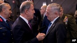 Le secrétaire américain à la Défense, Jim Mattis, à droite, avec le ministre turc de la Défense, Hulusi Akar, lors d'une réunion des ministres de la Défense de l'OTAN à Bruxelles, le 4 octobre 2018.