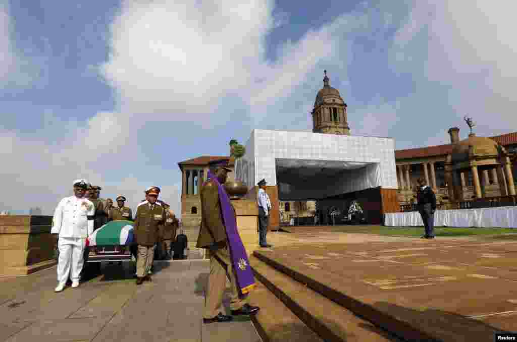 Military personnel carry the remains of the late Nelson Mandela upon arrival at the Union Buildings in Pretoria, Dec. 11, 2013.