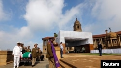 Military personnel carry the remains of the late Nelson Mandela upon arrival at the Union Buildings in Pretoria, Dec. 11, 2013.