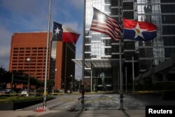 Flags fly at half-staff at a makeshift memorial near the crime scene two days after a gunman ambushed and killed five police officers at a protest decrying police shootings of black men, in Dallas, July 9, 2016.