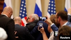 Petugas keamanan mengawal wartawan AS, Sam Husseini, keluar ruangan menjelang jumpa pers Presiden AS Donald Trump dan Presiden Rusia Vladimir Putin di Helsinki, Finlandia, Senin (16/7). 