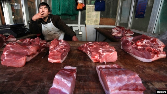 山西省长治市一名小贩在猪肉摊前等待顾客。