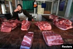 Penjual daging babi menunggu pelanggan di kiosnya di Changzhi, Provinsi Shanxi, 3 Maret 2008.