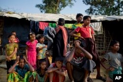 FILE - Rohingya Muslims, who crossed over from Myanmar into Bangladesh, wait to collect aid at Kutupalong refugee camp in Ukhiya, Bangladesh, Dec. 21, 2017.