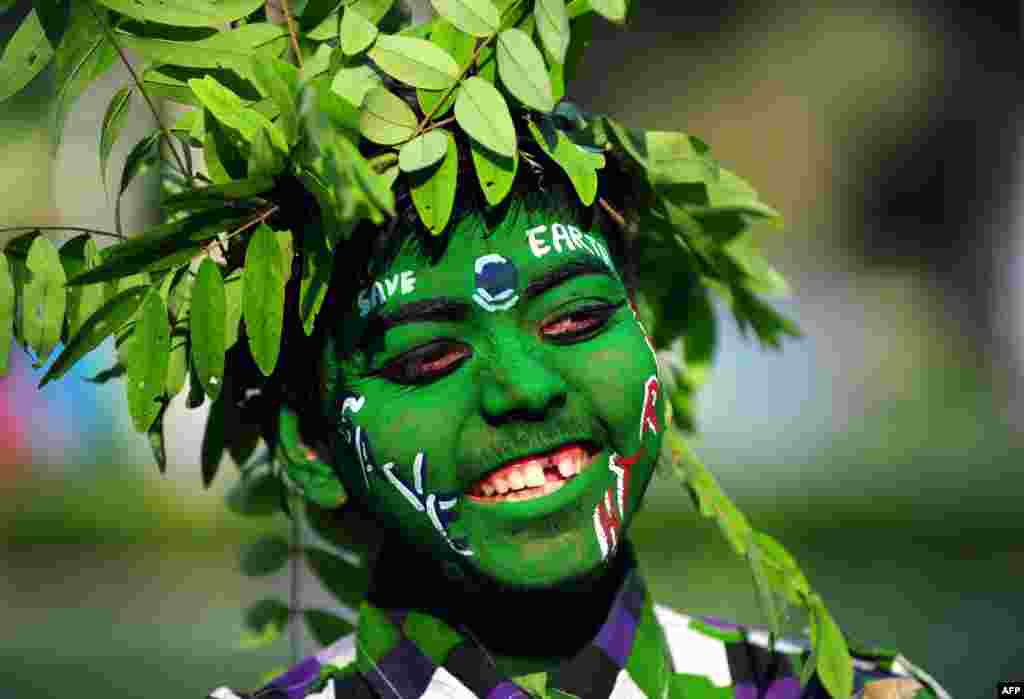 An Indian youth dressed as a tree looks on during an awareness event commemorating Earth Day in Allahabad. As the world marks the annual event environmental groups are pushing for stronger forest and wildlife protection and conservation.