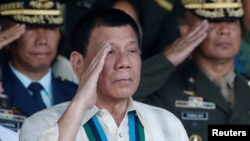 FILE - Philippine President Rodrigo Duterte salutes with other military officers during a anniversary celebration of the Armed Forces at a military camp in Quezon city, Manila.