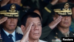 Philippine President Rodrigo Duterte salutes with other military officers during a anniversary celebration of the Armed Forces at a military camp in Quezon city, Manila, Dec. 21, 2016.