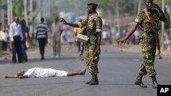 Un manifestant gisant sur l'asphalte à Bujumbura, lundi 18 mai 2015.