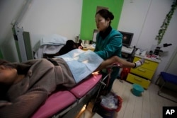 资料照：中国陕西省西安市一所堕胎诊所里，一名护士在给一名怀孕三个月的女子做检查。（2010年12月13日）