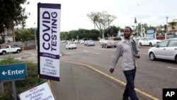 A man walks past a mobile COVID-19 testing site in Durban, South Africa, Dec. 3, 2021.