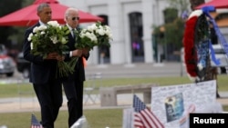 President Barack Obama, left, and Vice President Joe Biden place flowers at a makeshift memorial for shooting victims of the massacre at a gay nightclub in Orlando, Fla., June 16, 2016. 