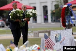 President Barack Obama, left, and Vice President Joe Biden place flowers at a makeshift memorial for shooting victims of the massacre at a gay nightclub in Orlando, Fla., June 16, 2016.