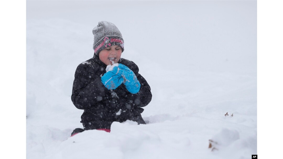 Joslyn Fontanellam, prueba un poco de nieve luego de limpiar la vereda de su casa. Greensboro, Carolina del Norte, domingo 9 de diciembre de 2018.
