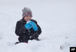 Joslyn Fontanellam, prueba un poco de nieve luego de limpiar la vereda de su casa. Greensboro, Carolina del Norte, domingo 9 de diciembre de 2018.