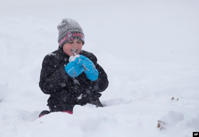 Joslyn Fontanellam, prueba un poco de nieve luego de limpiar la vereda de su casa. Greensboro, Carolina del Norte, domingo 9 de diciembre de 2018.