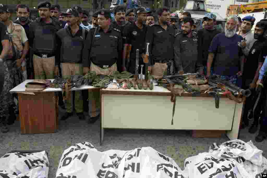 Police officers display confiscated ammunition and the dead bodies of terrorists who attacked the Jinnah International Airport in Karachi, Pakistan, June 9, 2014.