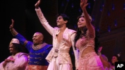 This image released by Disney Theatrical Productions shows, from second left, Michael James Scott as Genie, Michael Maliakel as Aladdin, and Shoba Narayan as Jasmine after a performance of the Broadway musical "Aladdin" in New York on Sept. 28, 2021.