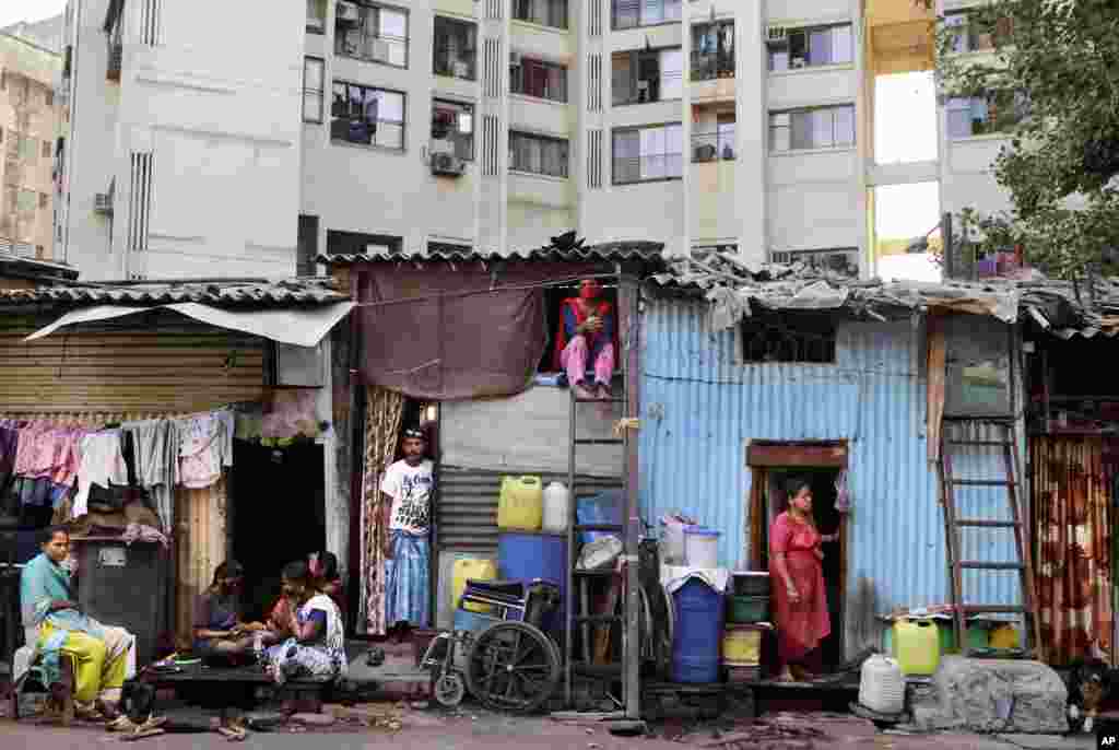 Impoverished Indians rest by their shanties at Dharavi, one of Asia&#39;s largest slums, during lockdown to prevent the spread of the coronavirus in Mumbai, India. 