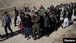 FILE - Mourners carry the body of a bombing victim in Kabul, Afghanistan, Jan. 21, 2016. A day earlier, a Taliban suicide bomber had targeted a minibus carrying Moby Group journalists.