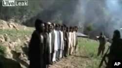 A still image taken from video released by Pakistani Taliban on July 18, 2011 shows masked militants lining up thirteen Pakistani security personnel before shooting them in firing squad style at an unknown location near the border between Pakistan and Afg