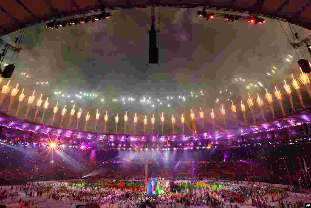 Para penari Samba tampil di saat kembang api yang menyala dalam upacara penutupan Olimpiade Musim Panas 2016 di Rio de Janeiro, Brazil (21/8). (AP/Natacha Pisarenko)