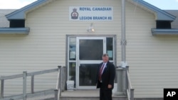 FILE - Gander, Newfoundland, Canada Mayor Claude Elliott stands in front of the Royal Canadian Legion Hall. At this remote town with a population of about 10,000 and an international airport built before World War II, 38 planes carried in 6,600 passengers