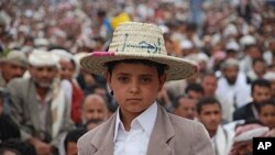 A young boy wears a straw hat with the Arabic word, "Leave," during an anti-government demonstration after Friday prayers in the Yemeni capital Sana'a, July 29, 2011