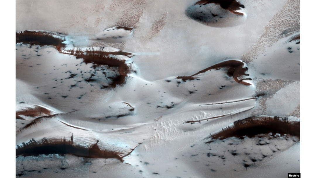 FILE - Water? Not anymore. Mars’ northernmost sand dunes are seen as they begin to emerge from their winter cover of seasonal carbon dioxide (dry) ice in this image acquired by the HiRISE camera aboard NASA's Mars Reconnaissance Orbiter, Jan. 16, 2014.