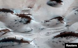 FILE - Water? Not anymore. Mars’ northernmost sand dunes are seen as they begin to emerge from their winter cover of seasonal carbon dioxide (dry) ice in this image acquired by the HiRISE camera aboard NASA's Mars Reconnaissance Orbiter, Jan. 16, 2014.