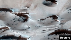 FILE - Water? Not anymore. Mars’ northernmost sand dunes are seen as they begin to emerge from their winter cover of seasonal carbon dioxide (dry) ice in this image acquired by the HiRISE camera aboard NASA's Mars Reconnaissance Orbiter, Jan. 16, 2014.