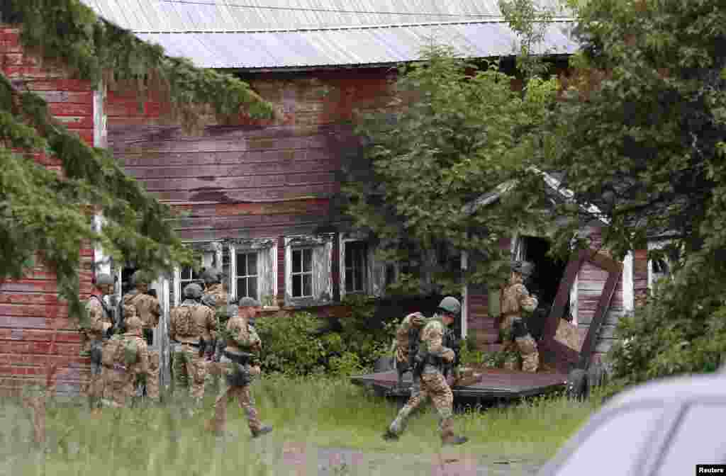 Police search a property near the Clinton Correctional Facility in Dannemora, New York, June 8, 2015. According to police, authorities hunting for two convicted murderers who staged a brash prison break in upstate New York were questioning a woman who worked at the maximum-security prison.