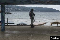 Seorang tentara berpatroli di pantai saat Badai tropis Rick menguat menjadi badai di lepas pantai Pasifik Meksiko, di Acapulco, Meksiko, 23 Oktober 2021. (REUTERS/Javier Verdin)