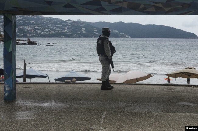 Seorang tentara berpatroli di pantai saat Badai tropis Rick menguat menjadi badai di lepas pantai Pasifik Meksiko, di Acapulco, Meksiko, 23 Oktober 2021. (REUTERS/Javier Verdin)