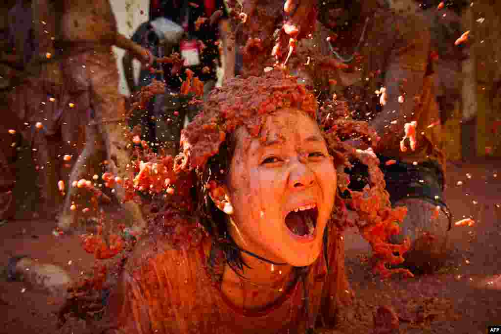 A woman covered in tomato takes part in the yearlyTomatina festival in the town of Bunol, near Valencia, Spain.