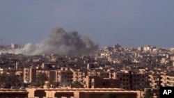 This frame grab from a video released Nov. 2, 2017, by the Syrian official news agency SANA shows smoke and debris rising after Syrian government shelling of the Deir el-Zour city during a battle against Islamic State militants. 